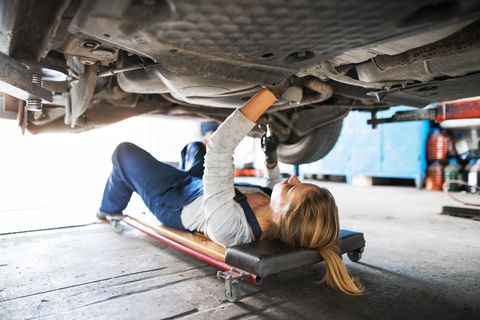 female mechanic repairing a car in a garage