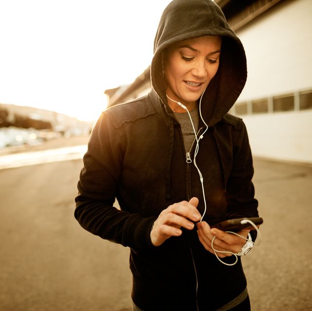 Female runner playing music on her mobile device.
