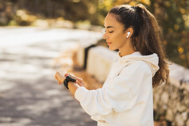 Woman looking at her sports watch while running