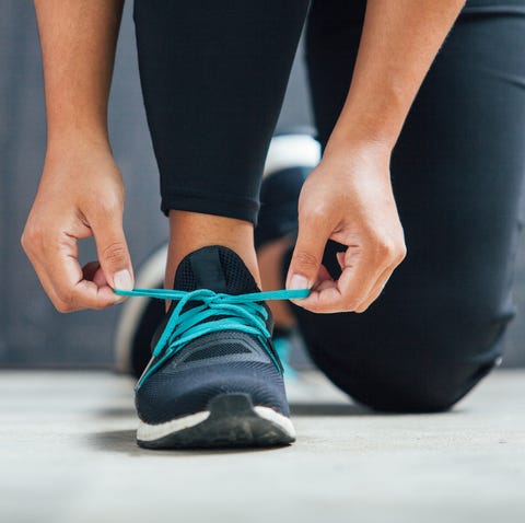 Female runner tying her shoes preparing for a run