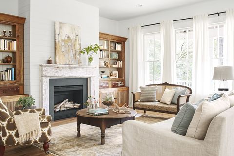 living room with neutral colors, rustic fireplace and linen couch