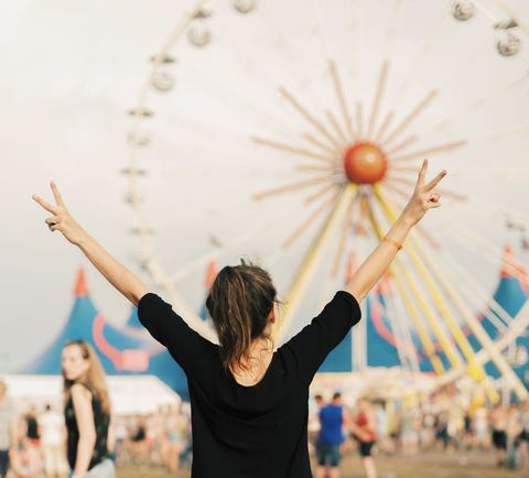 meisje met armen in de lucht op een festivalterrein