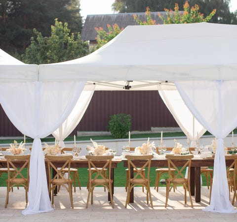 festive table under the white canopy near the swimming pool