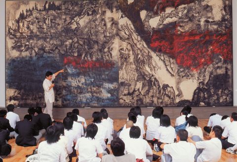 『沖縄戦の図』（丸木位里・丸木俊　1984年）修学旅行生に絵の解説をする佐喜眞道夫館長。