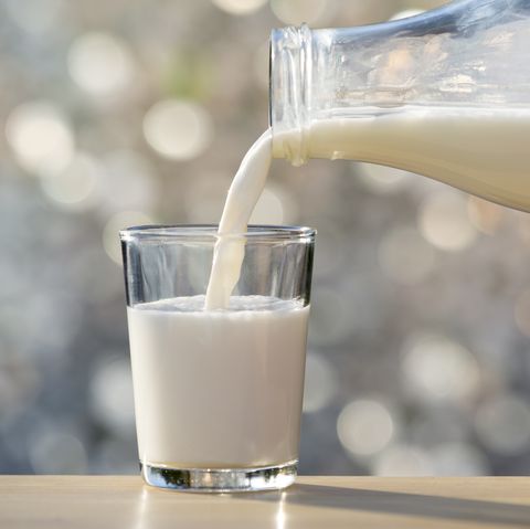 Filling of a glass of milk in a glass glass with natural light