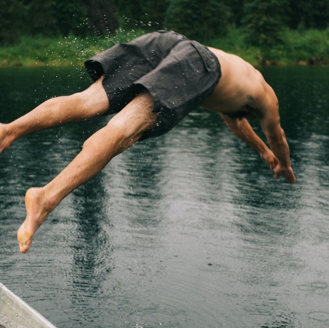 man jumping into a lake
