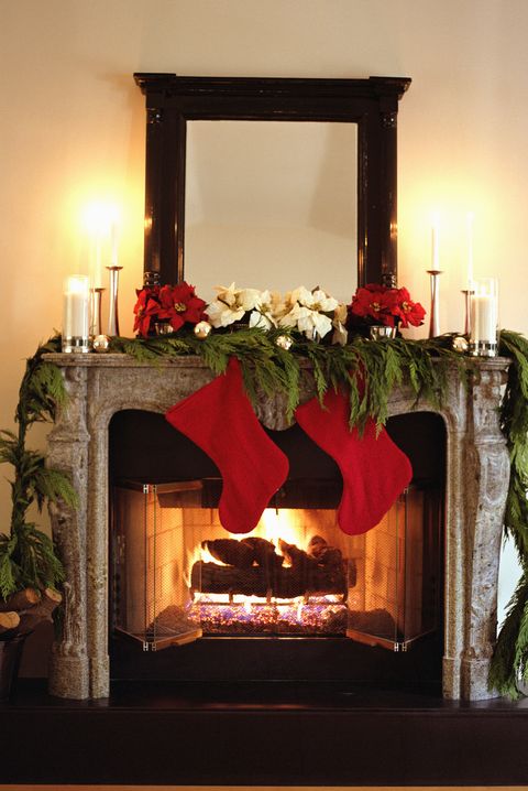 Fireplace decorated with Christmas stockings and Poinsettias