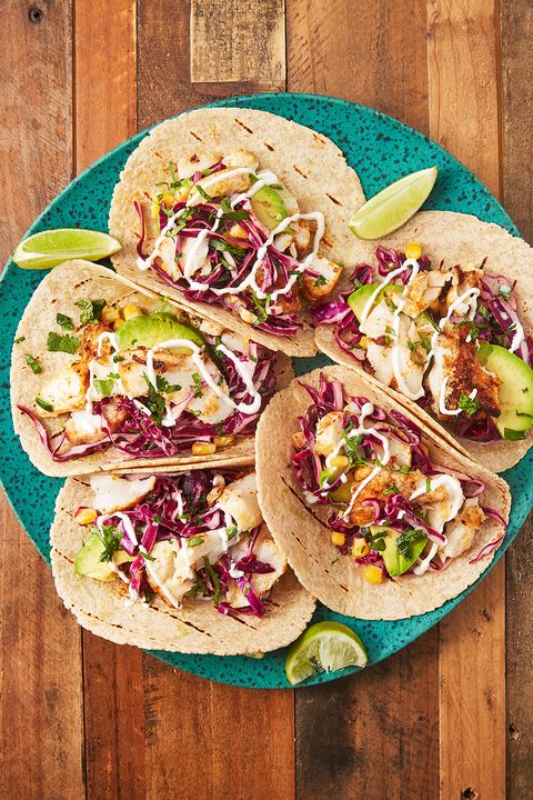 fish tacos with avocado, corn, and red cabbage slaw on a teal plate