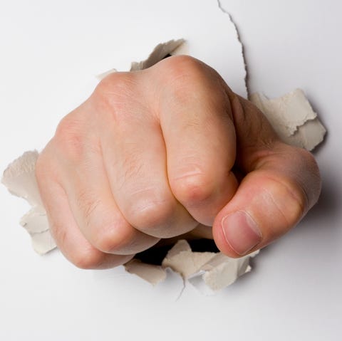 A fist breaking through a wall A fist breaking through a wall