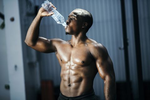 fit and mascular man drinking water
