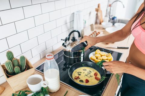 Fit woman preparing healthy breakfast in kitchen