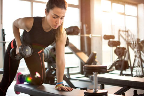 Ragazza fitness che solleva il manubrio al mattino.