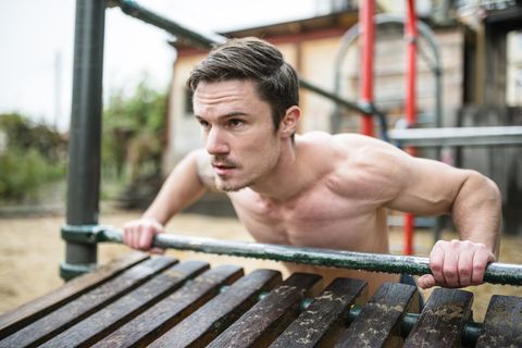 Fitness man doing push-ups at the outdoors park