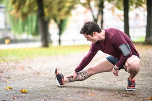 Fitness man stretching the calf in berlin after run
