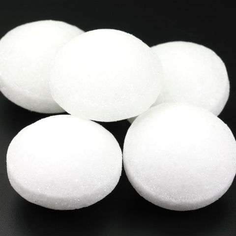 Five white naphthalene balls on black background