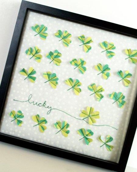 framed fabric clover specimen art with four rows of fabric clover and one row second from the bottom with one clover and the world lucky sewn next to it