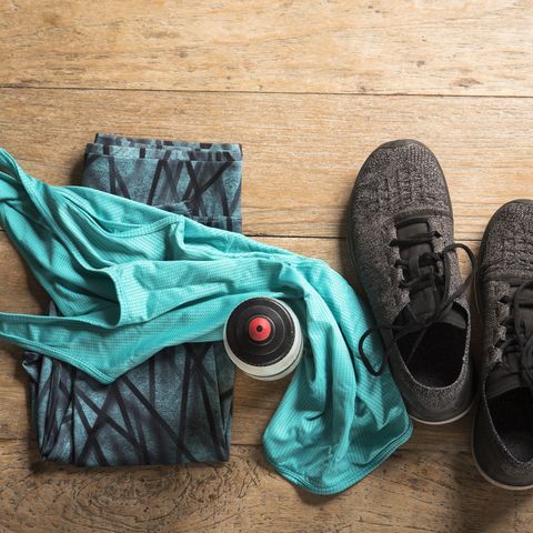 Flat Lay image of sports clothes and shoes on a wooden floor.