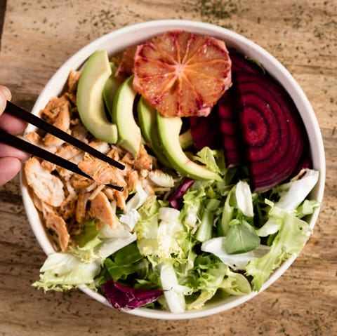 young man eating a buddha bowl young man eating a buddha bowl