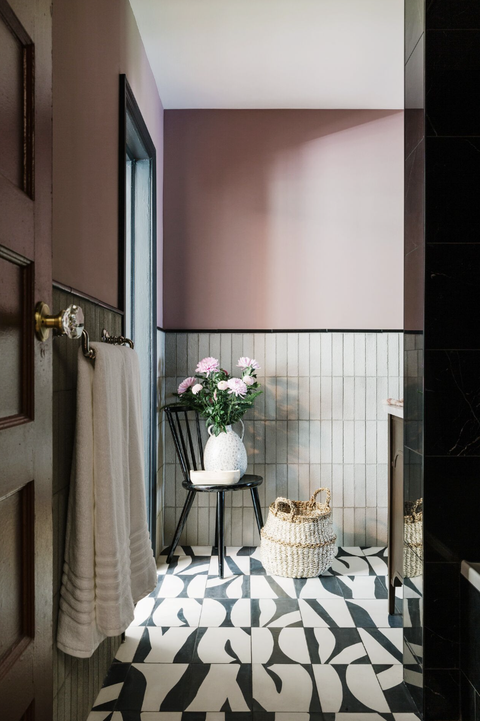 bathroom with black and white tiles and pink walls