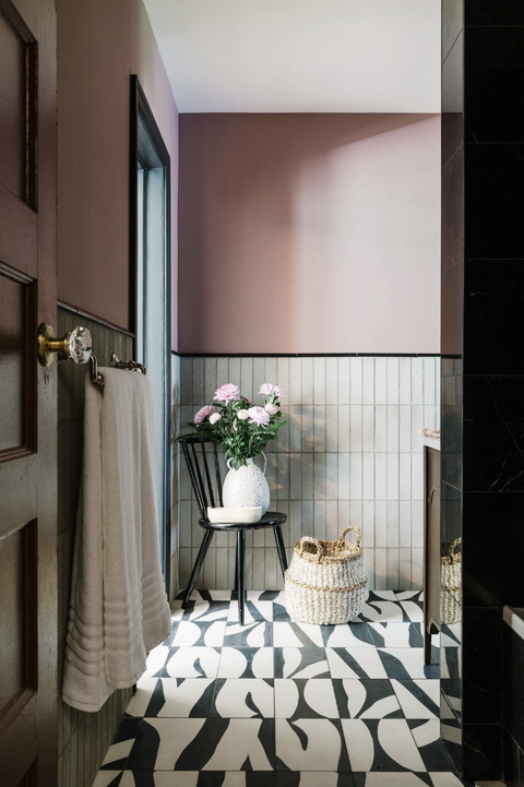 bathroom with black and white tiles and pink walls