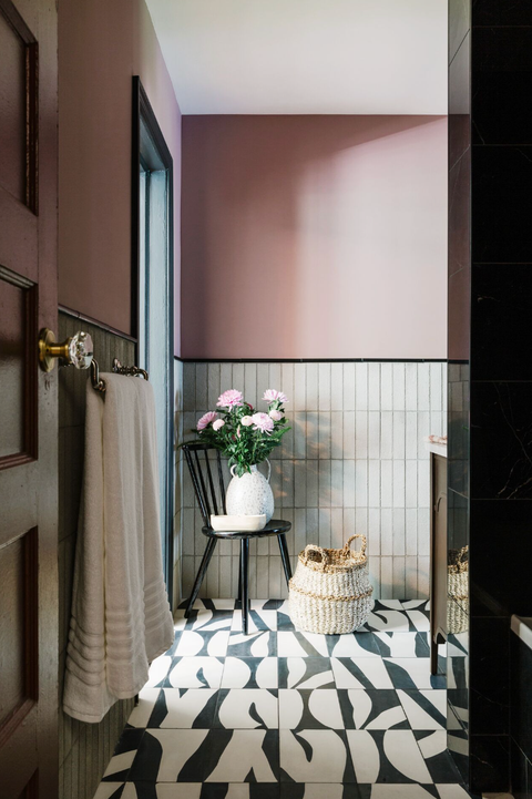 bathroom with black and white tiles and pink walls