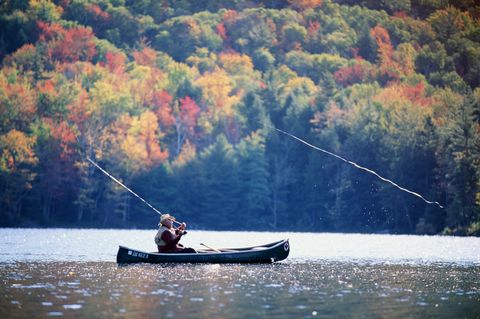 fly fisherman in canoe, vermont, usa