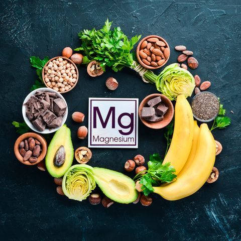 Foods containing natural magnesium. Mg: Chocolate, banana, cocoa, nuts, avocados, broccoli, almonds. Top view. On a black background.
