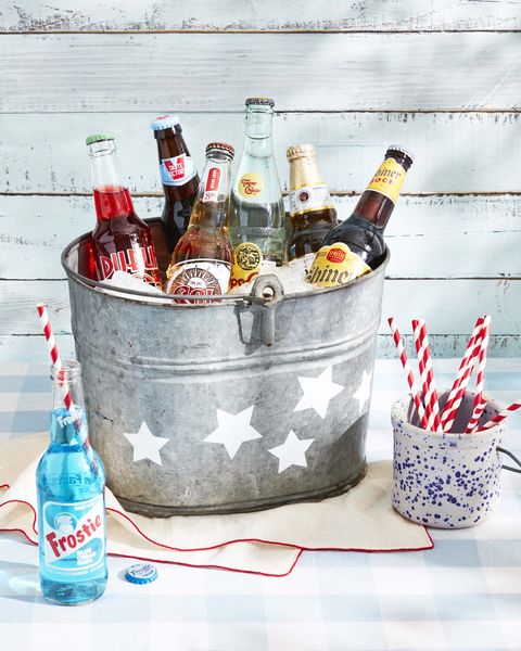 beers and sodas in a vintage metal cooler that has white stars painted on the outside