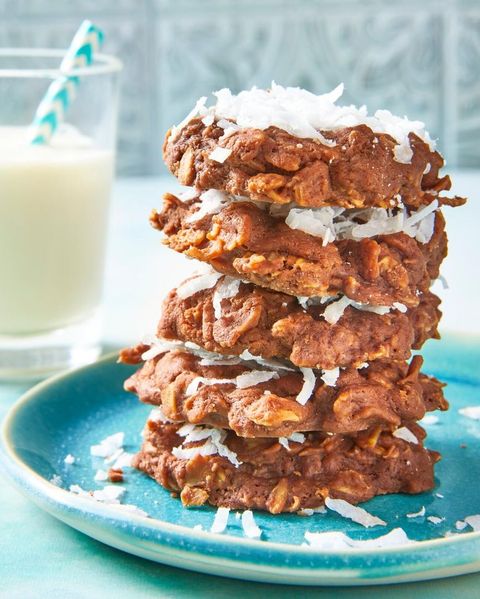 no bake chocolate oatmeal cookies stacked on blue plate with glass of milk
