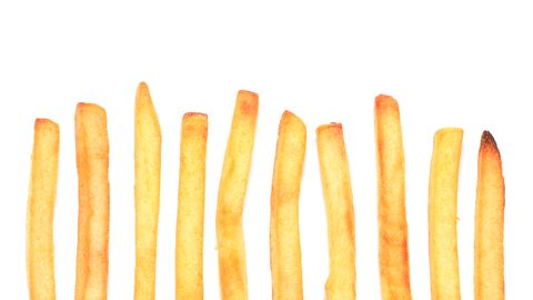 French fries in a row on white background