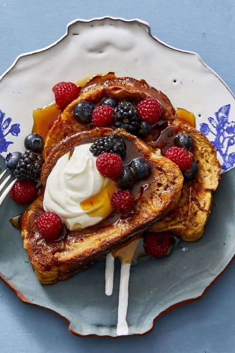 french toast with berries, cream and syrup on top