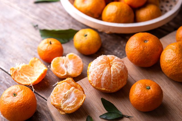 fresh mandarin oranges fruit or tangerines with leaves on a wooden table