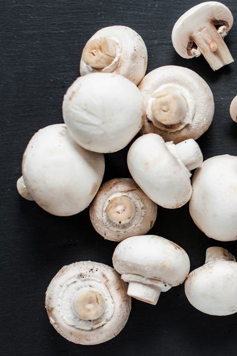 FreshMushroom champignon on dark   background, sliced and whole with copy space, ready for cooking