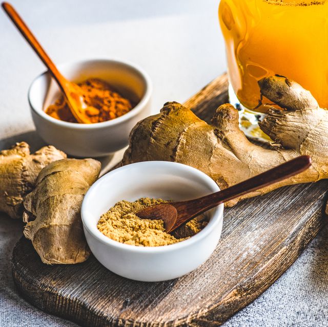 fresh turmeric, ginger and orange drink with ingredients on a table