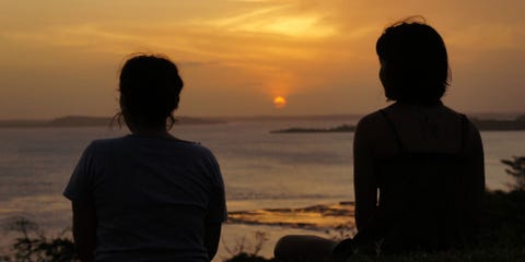 Women sitting on the beach at sunset