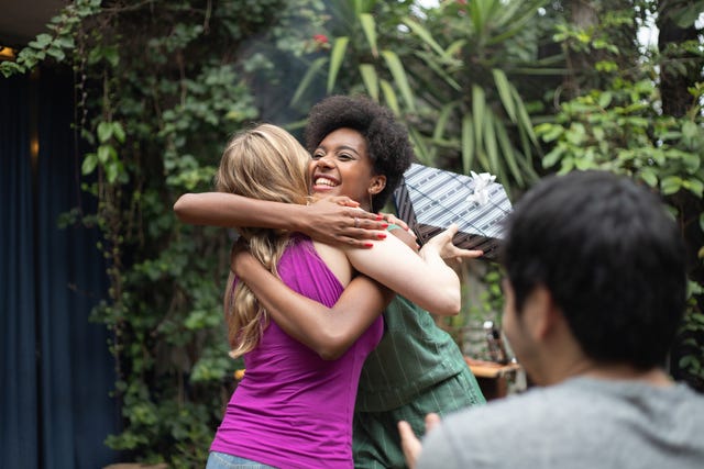 friends giving presents at barbecue birthday party