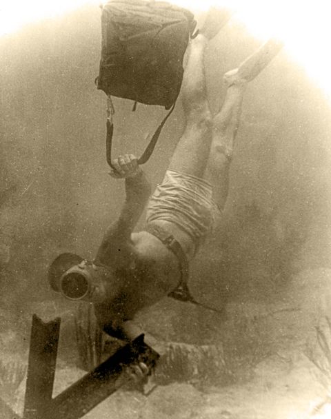 wwii frogman attaches demolition to underwater obstacle