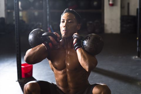Front view of athlete doing kettle bell squats, San Diego, California, USA