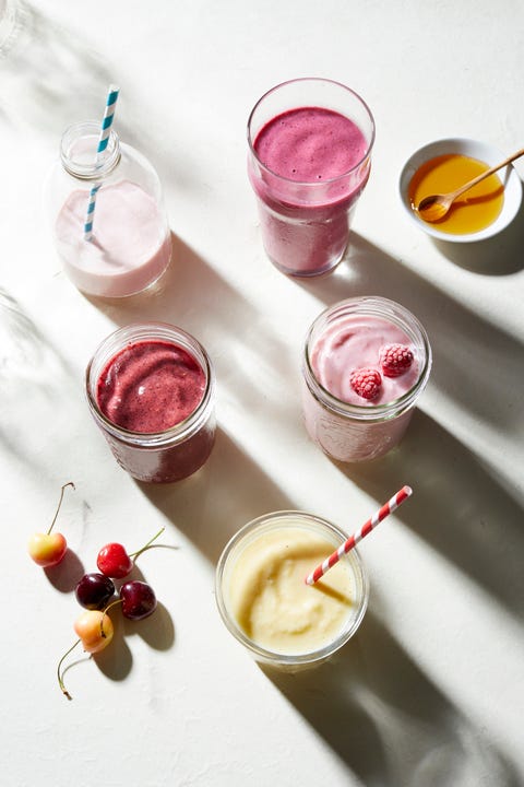 Fruit and yogurt smoothies in glass bottle and jars, overhead view