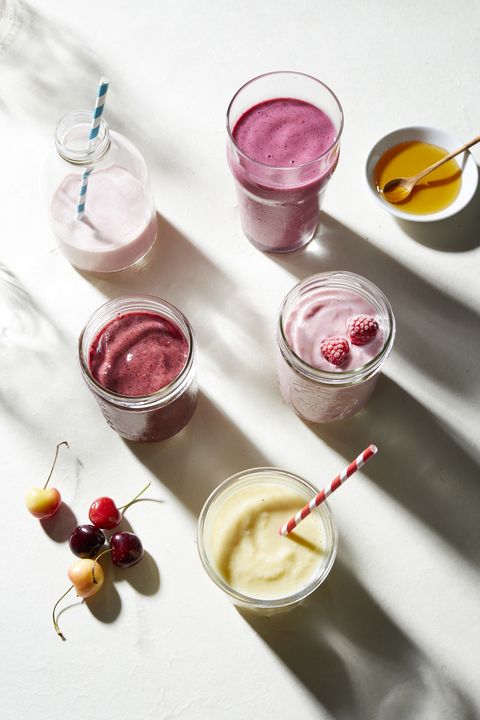 Fruit and yogurt smoothies in glass bottle and jars, overhead view