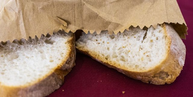 full frame shot of sliced apulian bread contained in a paper bag with red background, italy