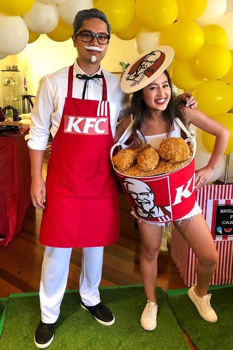 bucket of fried chicken costume with colonel sanders in white plus red kfc apron, black western tie, white mustache, goatee