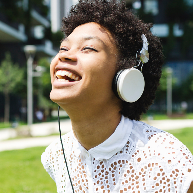 woman laughing in headphones podcasts
