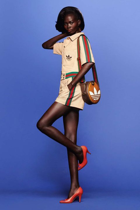 a model wears an adidas gucci jumpsuit in front of a plain backdrop to illustrate a news post about adidas gucci 2022