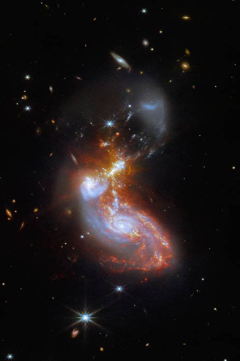 a merging galaxy pair cavort in this image captured by the nasaesacsa james webb space telescope this pair of galaxies, known to astronomers as ii zw 96, is roughly 500 million light years from earth and lies in the constellation delphinus, close to the celestial equator as well as the wild swirl of the merging galaxies, a menagerie of background galaxies are dotted throughout the imagethe two galaxies are in the process of merging and as a result have a chaotic, disturbed shape the bright cores of the two galaxies are connected by bright tendrils of star forming regions, and the spiral arms of the lower galaxy have been twisted out of shape by the gravitational perturbation of the galaxy merger it is these star forming regions that made ii zw 96 such a tempting target for webb the galaxy pair is particularly bright at infrared wavelengths thanks to the presence of the star formation this observation is from a collection of webb measurements delving into the details of galactic evolution, in particular in nearby luminous infrared galaxies such as ii zw 96 these galaxies, as the name suggests, are particularly bright at infrared wavelengths, with luminosities more than 100 billion times that of the sun an international team of astronomers proposed a study of complex galactic ecosystems — including the merging galaxies in ii zw 96 — to put webb through its paces soon after the telescope was commissioned their chosen targets have already been observed with ground based telescopes and the nasaesa hubble space telescope, which will provide astronomers with insights into webb’s ability to unravel the details of complex galactic environments webb captured this merging galaxy pair with a pair of its cutting edge instruments nircam — the near infrared camera — and miri, the mid infrared instrument if you are interested in exploring the differences between hubble and webb’s observations of ii zw 96, you can do so heremiri was contributed by esa and nasa, with the instrument designed and built by a consortium of nationally funded european institutes the miri european consortium in partnership with jpl and the university of arizona the university of arizona also provided the nircam instrument image description a galaxy merger lies in the centre of this image the cores of the galaxies, coloured blue, are below centre they are surrounded by red star forming regions which stretch up through and above the centre faint yellow diffraction spikes appear in the middle the lower galaxy is a mostly regular spiral shape, while the upper galaxy has been distorted heavily the background is black, and covered with many tiny galaxies throughout the scene links  slider tool zoom into ii zw 96 pan of ii zw 96 hubble and webb observe ii zw 96