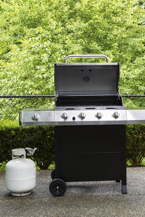 Gas grill with white tank on outdoor patio