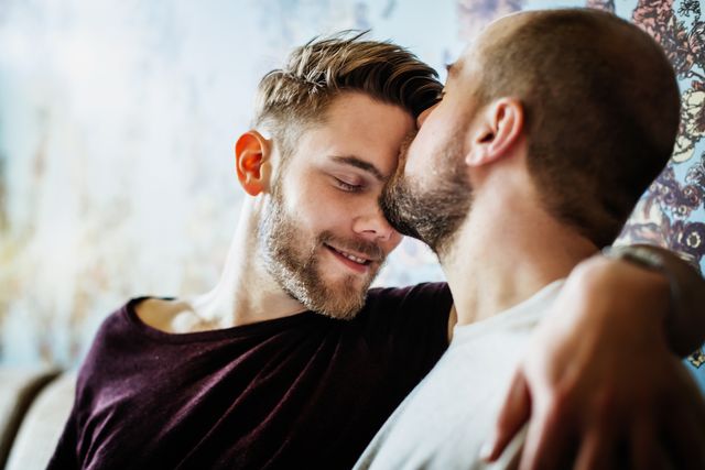 gay man kissing his partner on the head