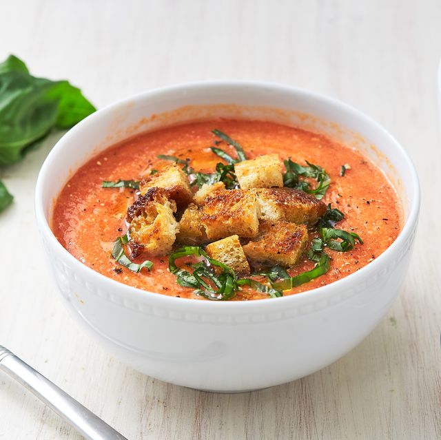 bowl of gazpacho garnished with basil and croutons
