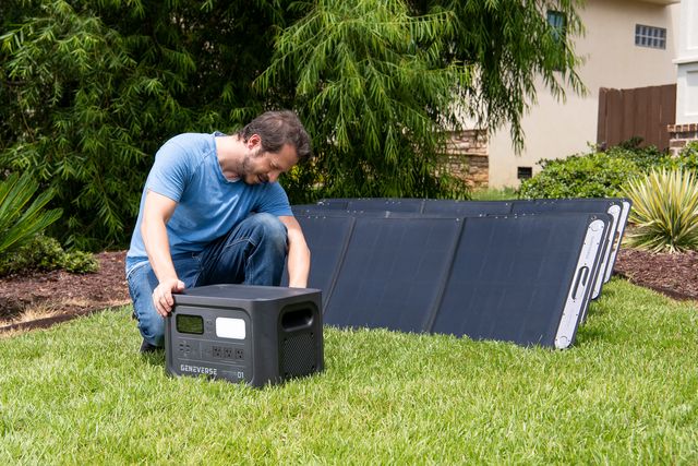 man plugging in a geneverse generator into solar panels