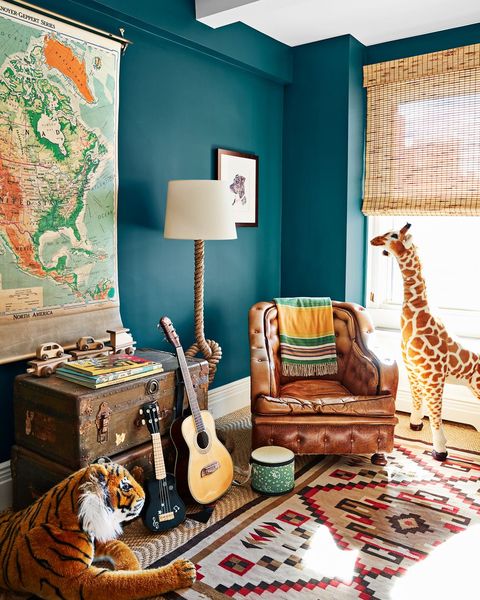 gender neutral nursery with deep turquoise walls and stuffed giraffe